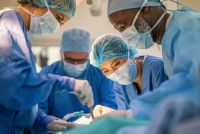 Chirurgen in operatiekleding voeren samen een medische ingreep uit in een operatiekamer.
