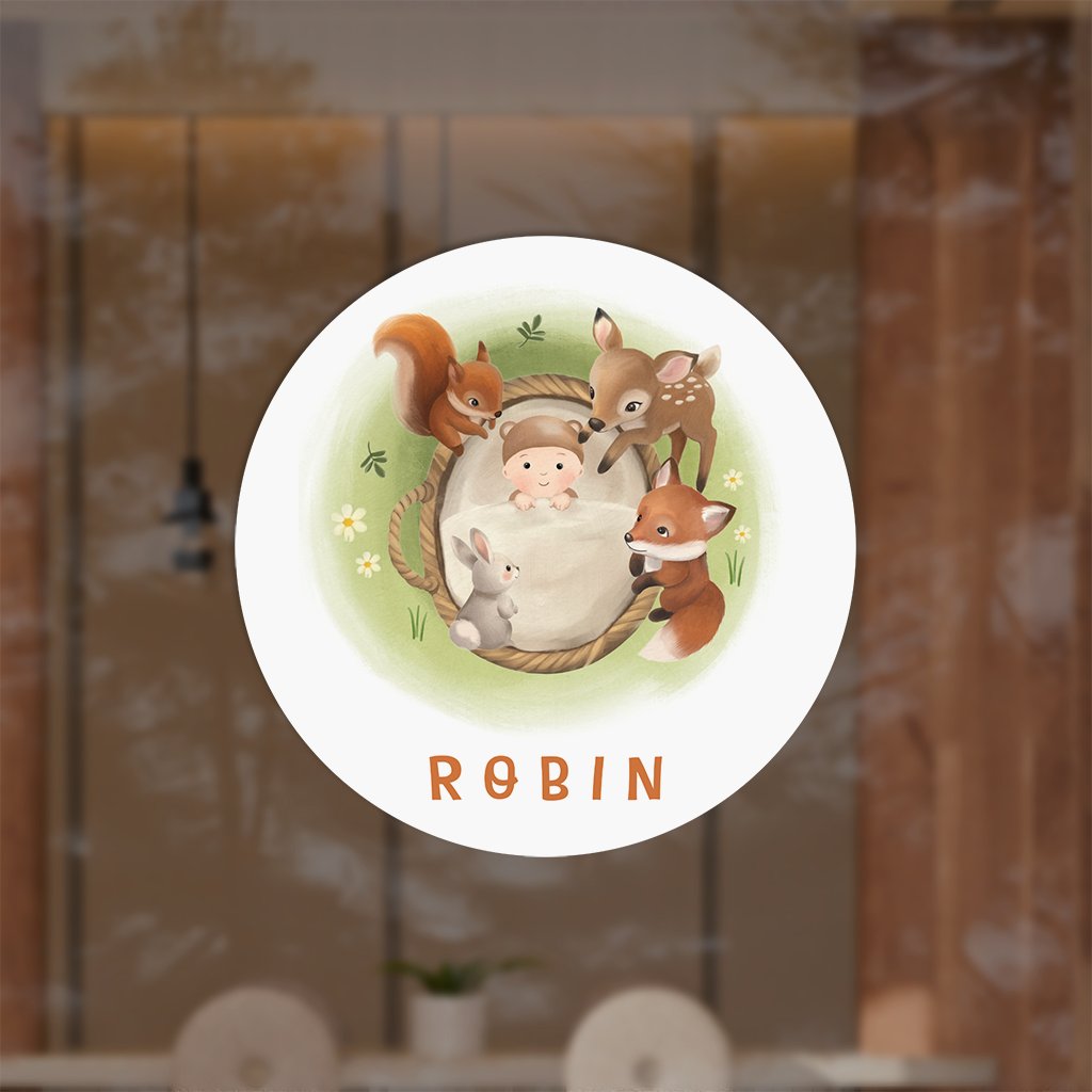 Raamsticker met baby mandje en bosdieren in gras