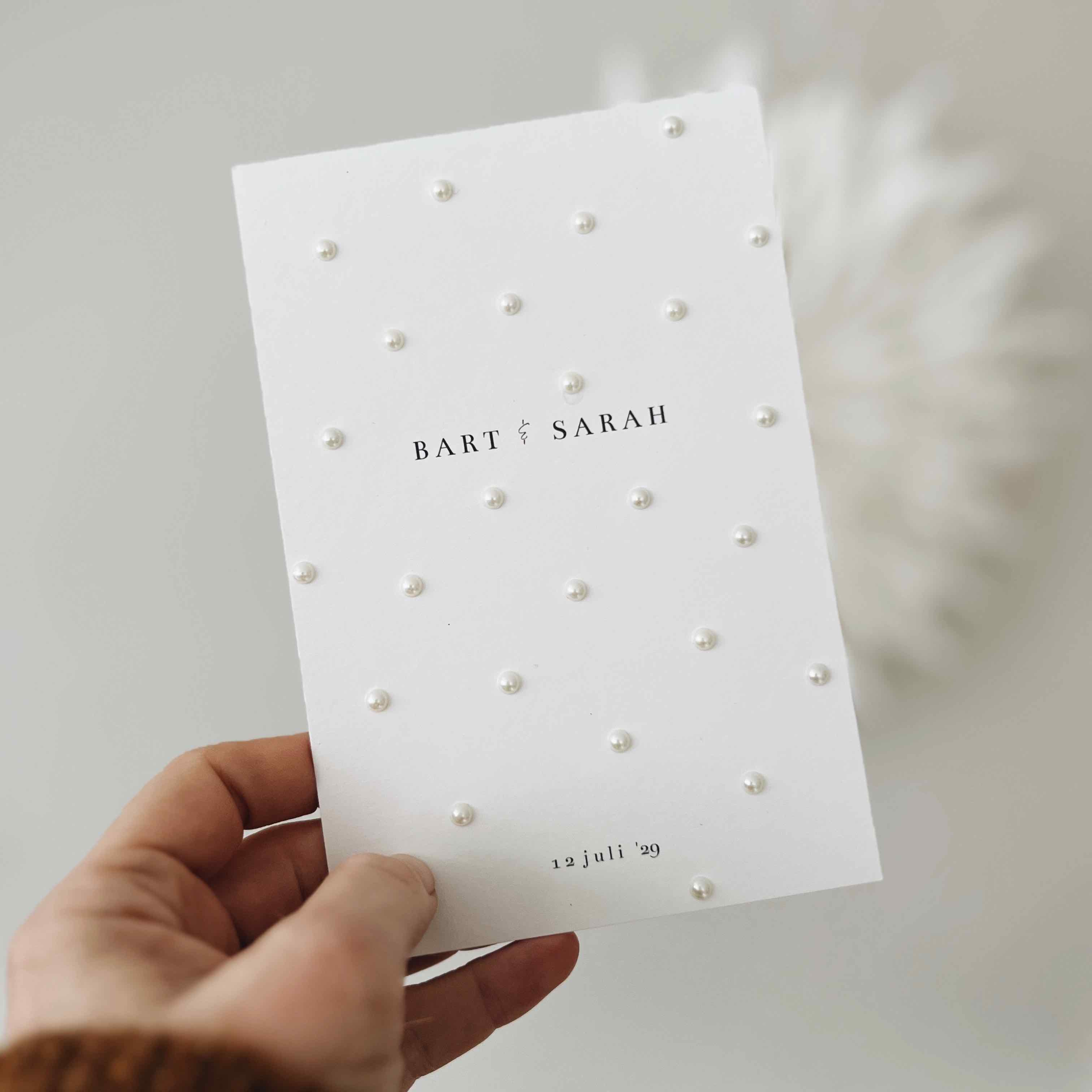 Klassieke trouwkaart wit met parel stickers erop geplakt