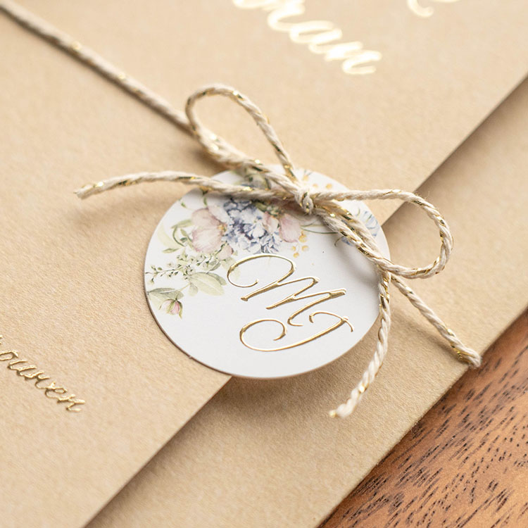 Rond labeltje met bloemen en logo bij trouwkaart