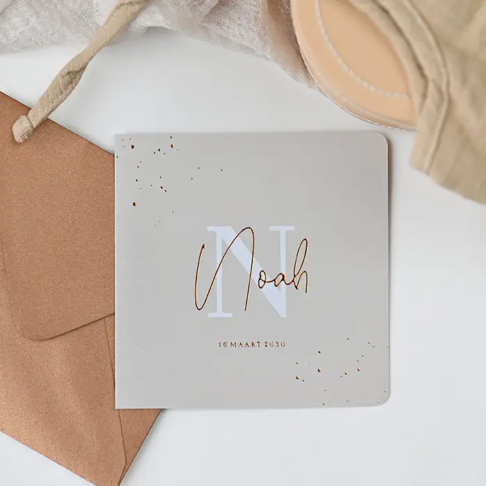 Luxe geboortekaartje met koperfolie, initiaal en lichte structuur
