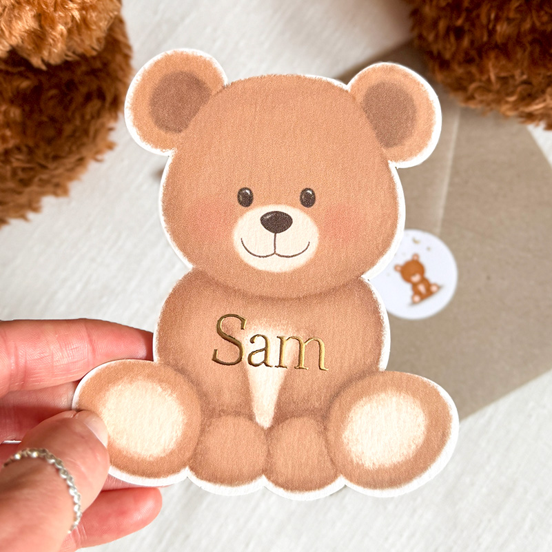Geboortekaartje in de vorm van een teddybeer met goudfolie naam