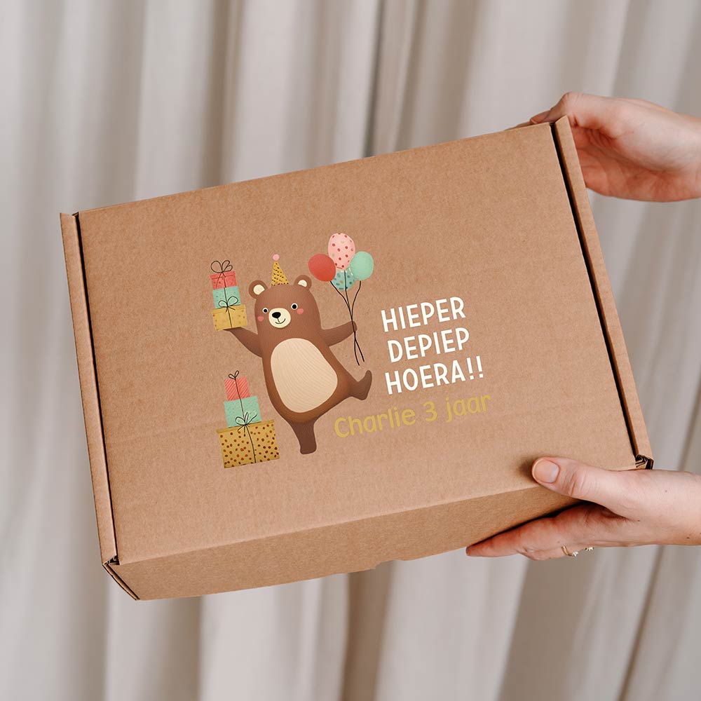 Vrolijke cadeaudoos van kraft met beer, cadeaus, ballonnen en leeftijd
