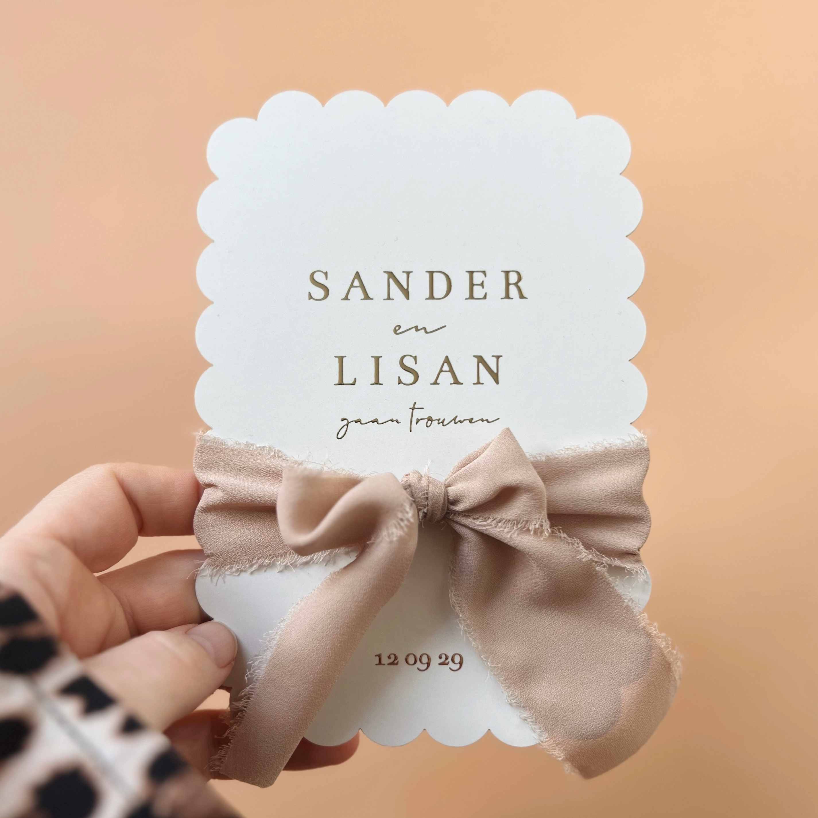 Klassieke trouwkaart koekjesvorm met goudfolie en bruin oranje lint