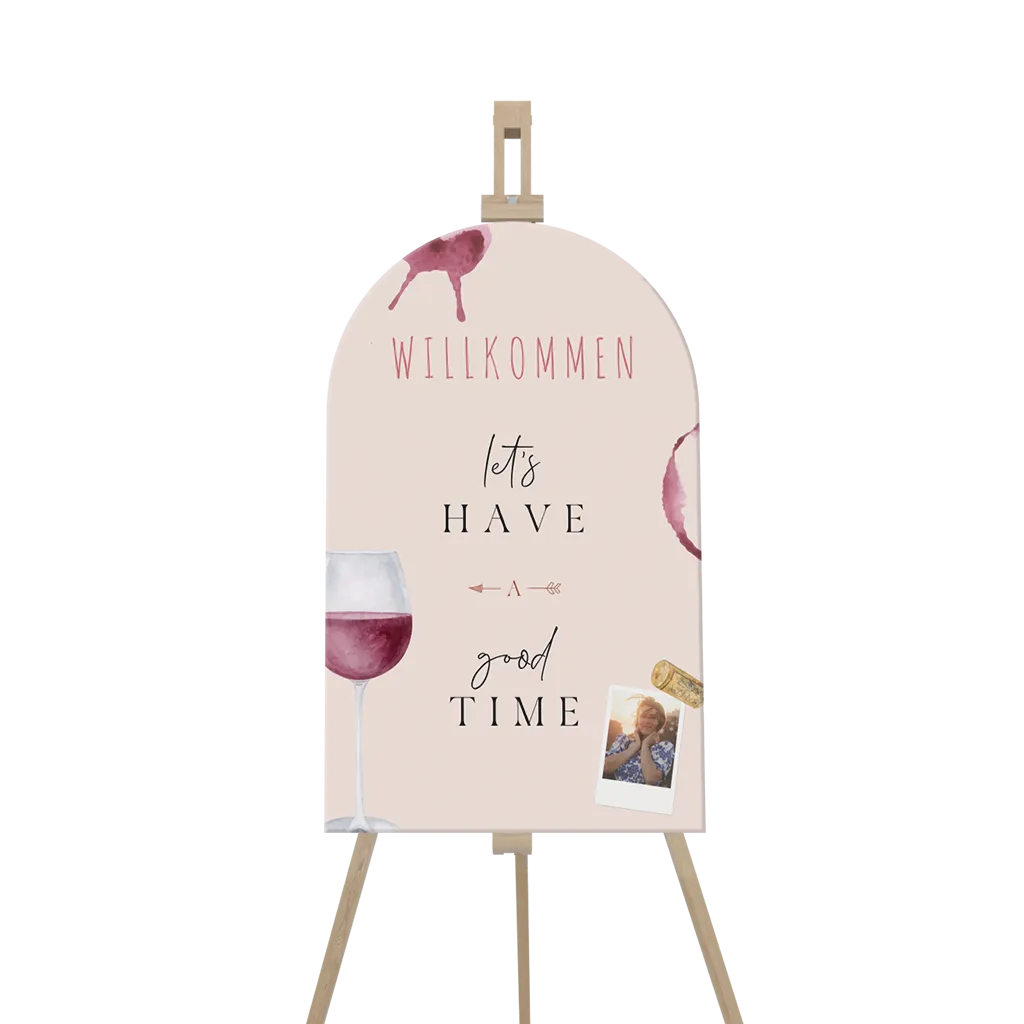 Willkommensschild in Bogenform mit Weingläsern und Foto