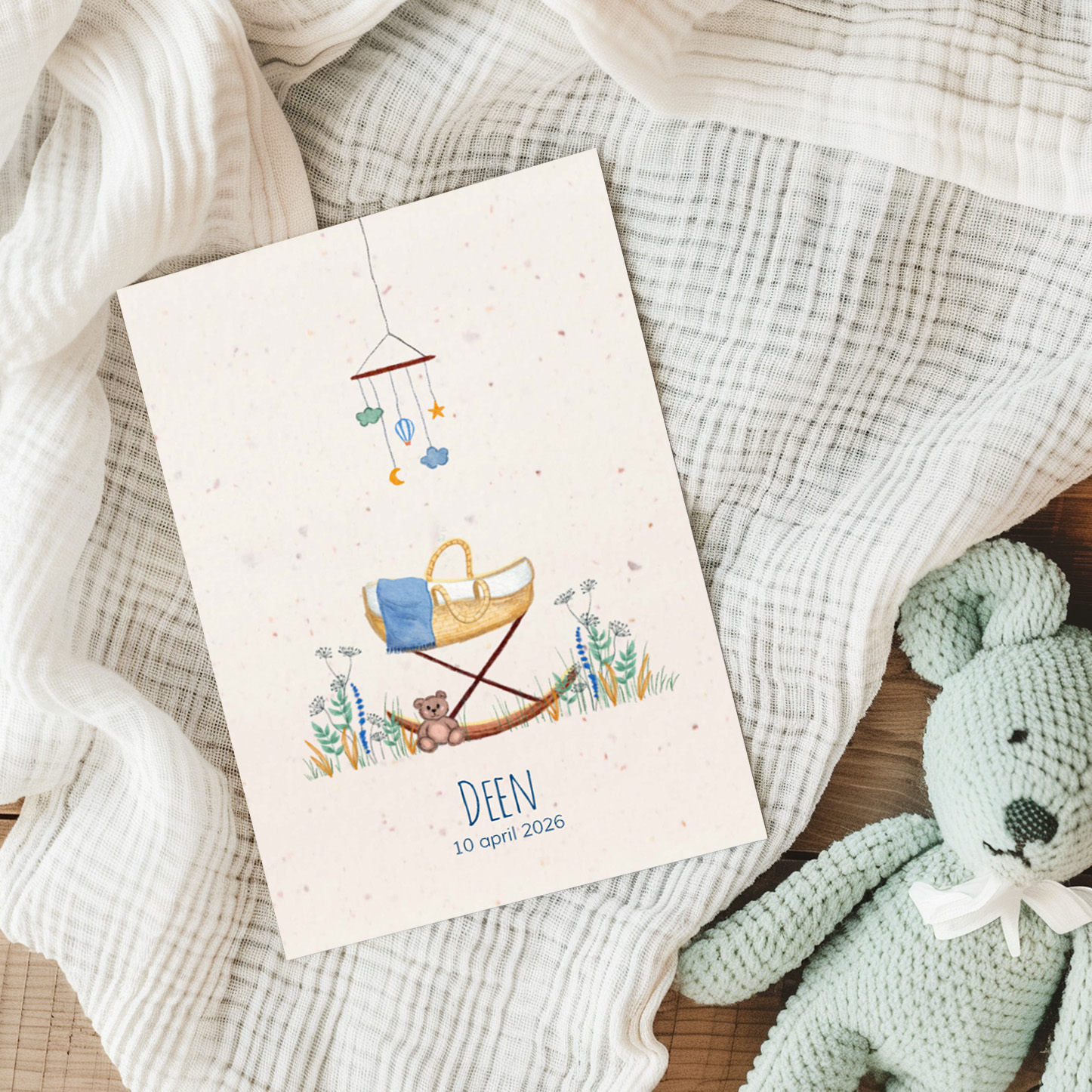 Geboortekaartje voor een jongen met wiegje in het gras