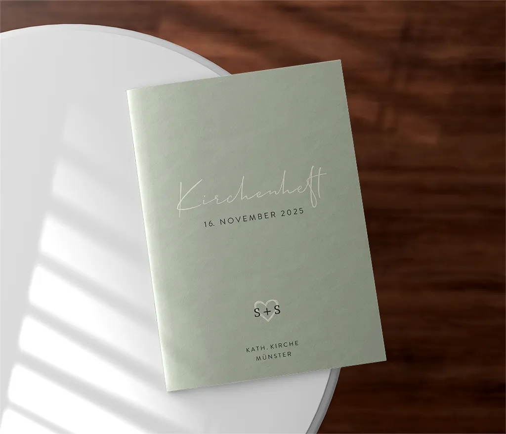 Kirchenheft in Grün mit weißer Schrift und Herz