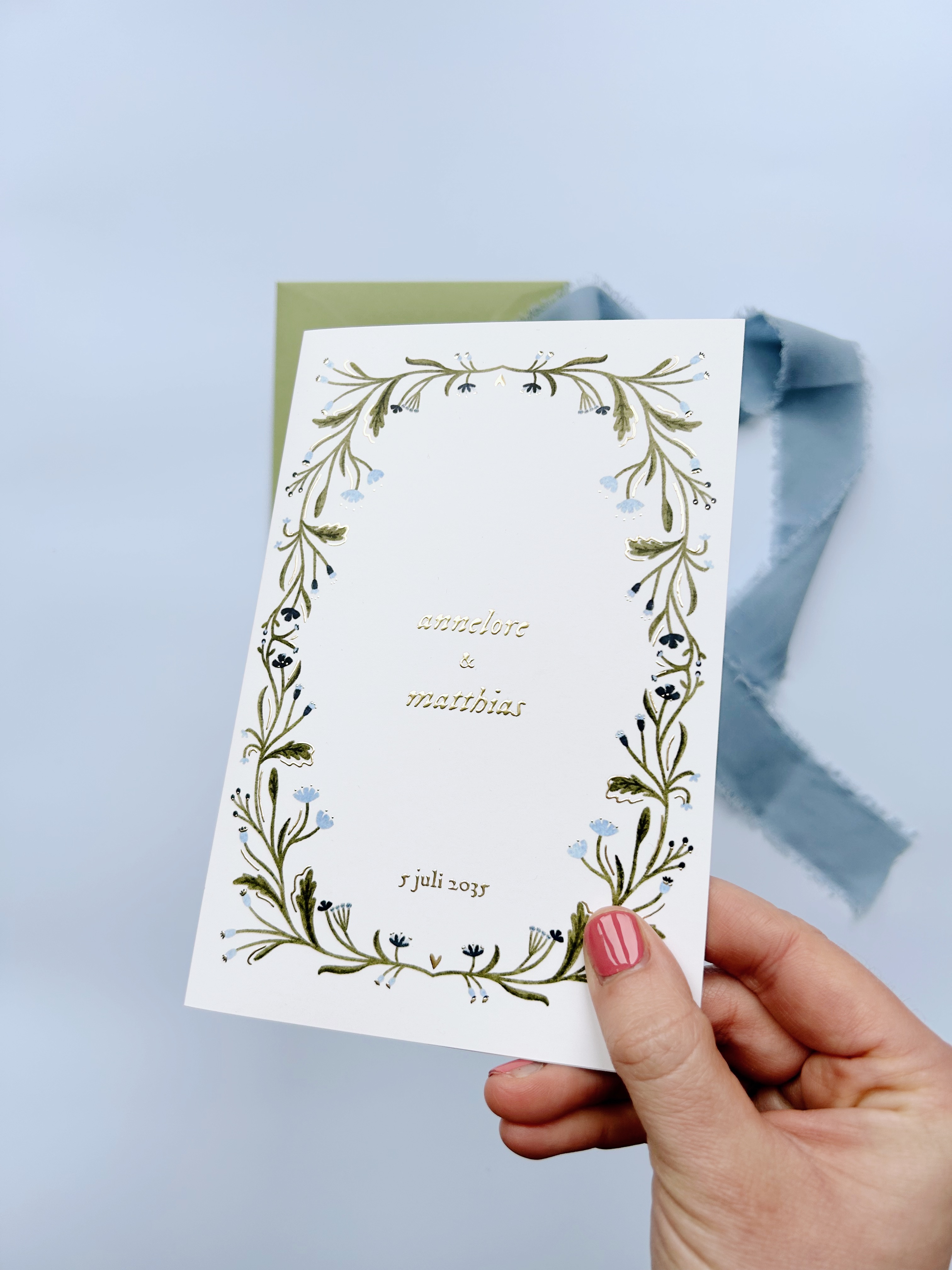 Trouwkaart met matte goudfolie en botanisch bloemenkader