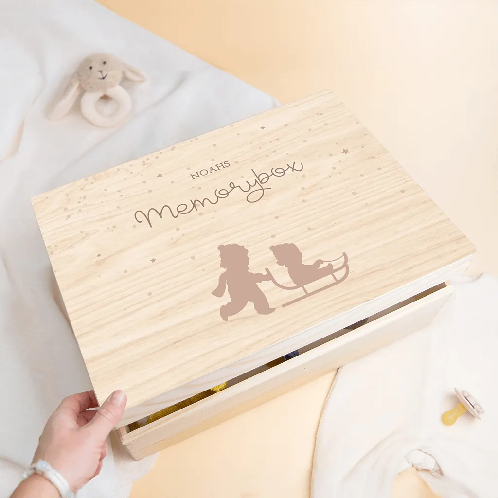 Winterliche Erinnerungskiste mit Geschwistern auf Schlitten