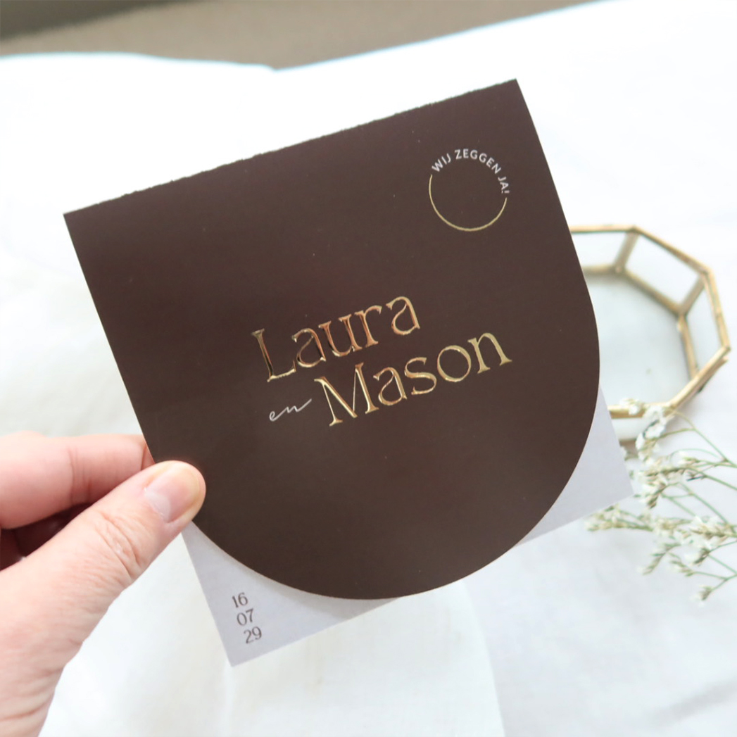 Luxe bruine trouwkaart met halfronde vorm en typografie in goudfolie